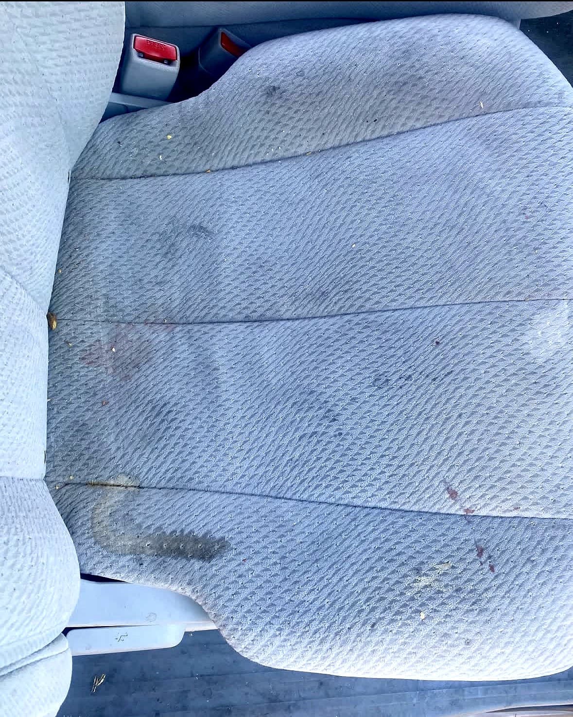 Cloth car seat before interior restoration, showing stains and dirt