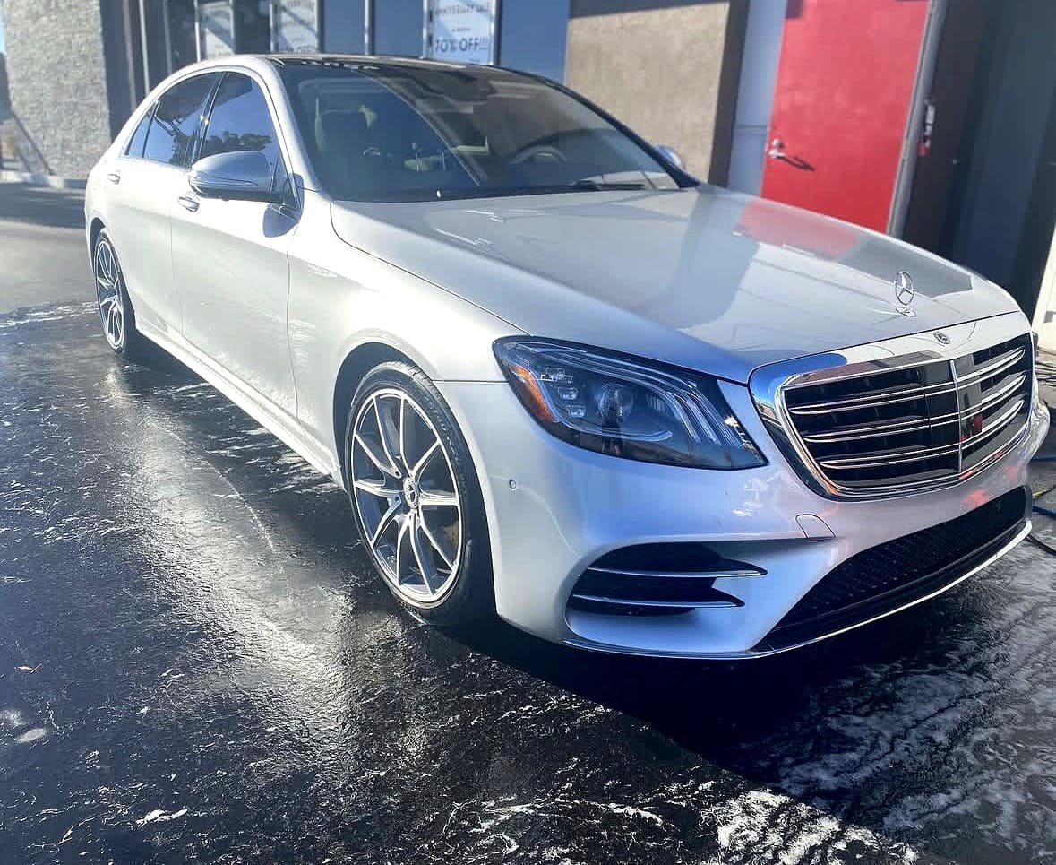 Freshly detailed silver Mercedes-Benz S-Class on wet pavement at a Las Vegas detailing shop
